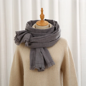 Deep grey solid color cashmere-like scarf with fine tassels on a wooden mannequin