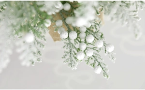 Detail of flocked Christmas cedar branch with white berries and burlap base decor