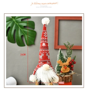 Close-up of a 26cm red knitted gnome wine bottle cover with reindeer patterns