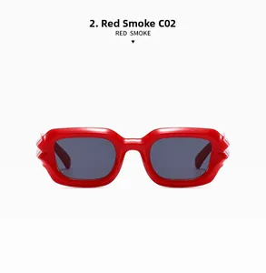 Detail view of bold red square punk sunglasses featuring high-quality smoke grey lenses