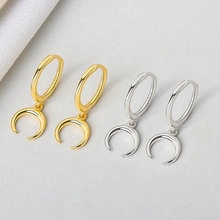 Detail view of gold and silver S925 sterling silver hoop earrings with crescent pendants