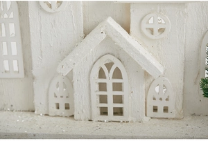 Macro detail of white wooden Christmas house with silver glitter and natural wood grain