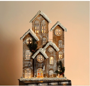 Close-up of wooden Christmas house ornament with warm LED lights and snowy details