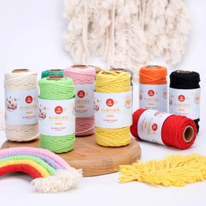 Close-up of colorful 1.5mm cotton twine rolls with DIY woven rainbow and feather decor