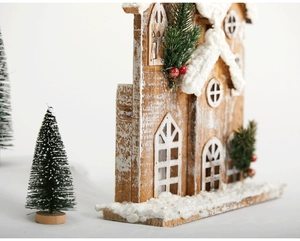 Close-up of white wooden Christmas house decor with snow, pine needles and red berries
