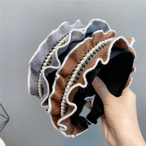 Elegant knitted ruffled headband with pearls in brown and blue for a vintage hair look