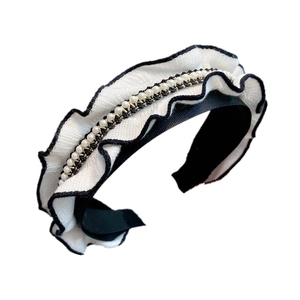 Detail of ruffle knit headband featuring white pearls and golden chain embellishments