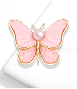 Pink pearl butterfly brooch with gold metal wings on a white minimalist display stand
