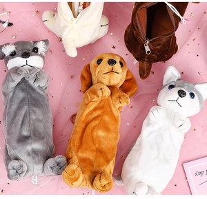 Flat lay of diverse plush dog pencil cases on pink sequined tulle background