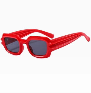 Detail of red punk sunglasses with unique lip-shaped frame and textured temples