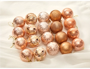 Detailed view of assorted 6cm champagne gold Christmas ornaments on white fabric