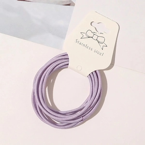 Macro shot of elastic purple hair ties wrapped on white Stainless Steel display card