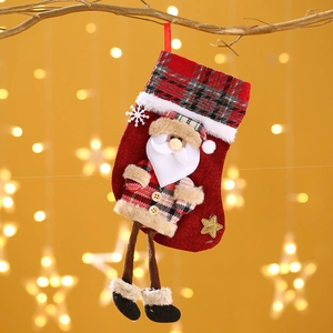 Detail eines roten karierten Nikolausstrumpfs mit 3D-Weihnachtsmann am Weihnachtsbaum
