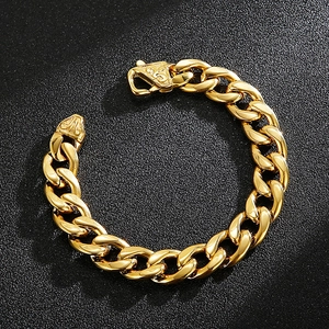 Close-up of golden Cuban link bracelet with engraved flat clasp on black background