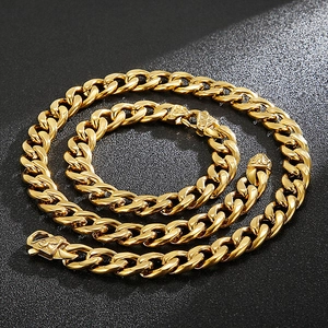 Macro view of gold flat Cuban link chain with detailed embossed clasp on black surface