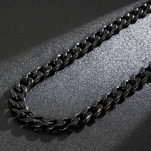 Detailed macro view of black stainless steel Cuban link chain necklace with polished finish