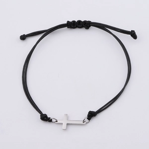Détail du bracelet en corde tissée noire avec un pendentif croix en acier poli