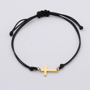 Détail d'un bracelet tissé noir ajustable avec un pendentif croix en acier doré poli