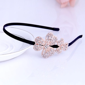 Close-up of black headband featuring golden rhinestones butterfly accents for kids