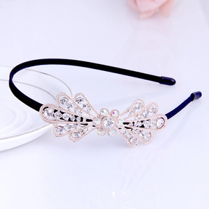 Detailed close-up of a velvet headband featuring a golden rhinestone bow ornament