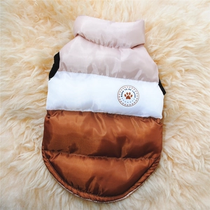 Dettaglio del gilet invernale per cani color block con toppa su sfondo in morbido peluche