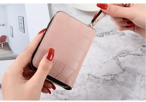 Detailed view of pink crocodile pattern card holder with zipper and wrist strap