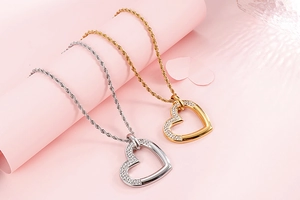 Détail de pendentifs cœur or et argent avec cristaux scintillants sur chaîne torsadée