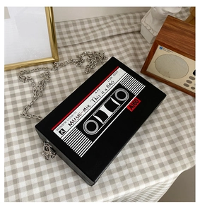 Retro cassette tape crossbody bag detail with chunky silver chain on vintage background