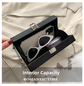 Detail view of black cassette box bag showing internal space for phone and makeup