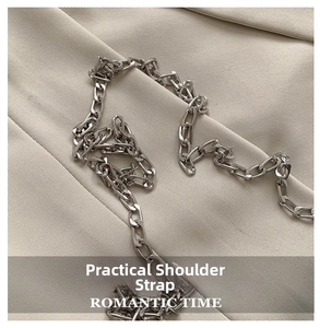 Close-up of the silver Cuban link metal chain strap on a neutral fabric background