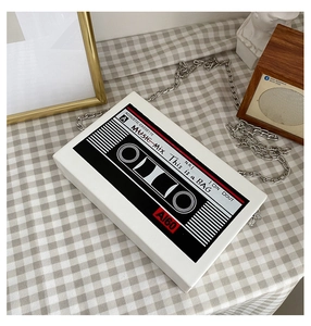 Detailed view of the creative retro cassette-shaped white crossbody bag on checkered cloth