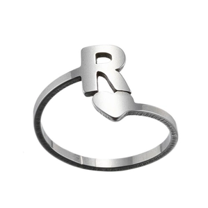Detailed close-up of a silver open ring featuring an uppercase R and heart decoration