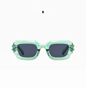 Detail of retro punk sunglasses with transparent green frames and spiked edge accents