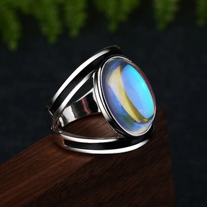 Close-up of a silver ring with a large oval rainbow gemstone and black enamel inlay