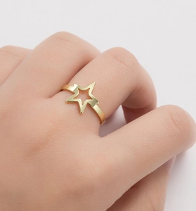 Close-up of a minimalist gold hollow star ring worn on a finger for style