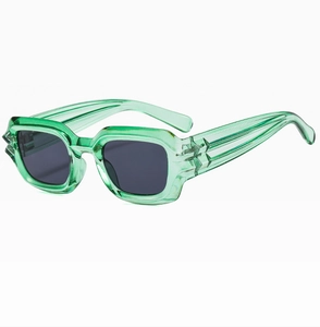 Close-up of retro thick transparent green frame sunglasses with dark gray lenses