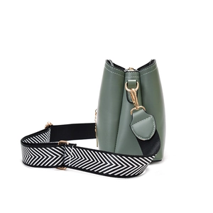Minimalist bean green bow shell bag with geometric shoulder strap shown from side view