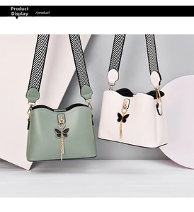 Fashionable shell bags in green and white with bow charms and striped wide straps