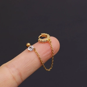 Detail of gold chain earring with crystal studs shown on finger for scale