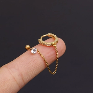 Macro shot of gold stainless steel double piercing earring with chain and crystals