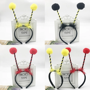 Detail of colorful ant insect headbands with fluffy pom-poms and feather accents for kids