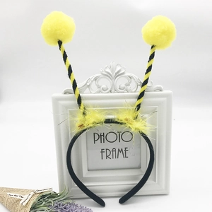 Detail of bee cosplay headband featuring yellow pom-poms, striped antennae and soft feathers