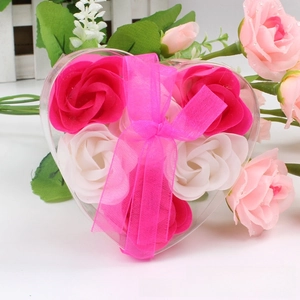 Macro view of heart-shaped gift box with pink and white rose soap flowers and ribbon