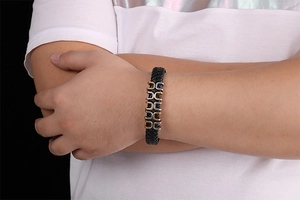 Men's black braided leather bracelet with gold and silver horseshoe metal clasps