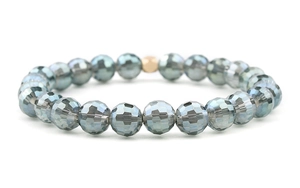 Macro shot of multifaceted gray-blue crystal beads with a single gold accent bead