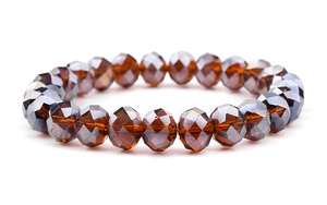 Macro shot of amber multifaceted glass beads with reflective crystal shine on elastic cord