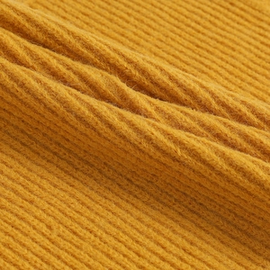 Macro shot of yellow knitted fabric showing detailed texture and yarn quality