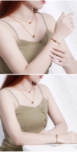 Detailed view of layered gold heart necklace and matching bracelet set worn by a model
