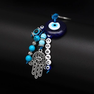Detail of Hamsa hand keychain with blue evil eye beads and Corfu letter beads