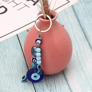 Detail of blue evil eye beads keychain hanging on a decorative pink flower vase
